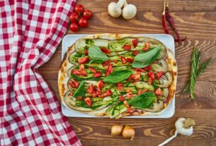 Delicious vegetable pizza with fresh basil, tomatoes, and eggplant, perfect for a healthy meal.