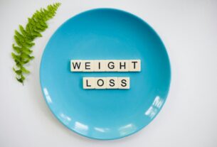 A blue plate with 'weight loss' tiles and a fern leaf on white background.