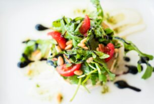 A vibrant arugula salad with cherry tomatoes, pine nuts, and balsamic glaze.