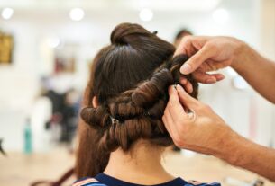 woman in blue shirt holding her hair