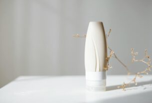 Elegant minimalist skincare bottle with dried branch, ideal for beauty and spa themes.